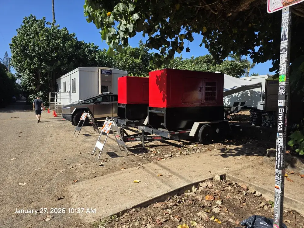 Red and white trailer generators on a job site