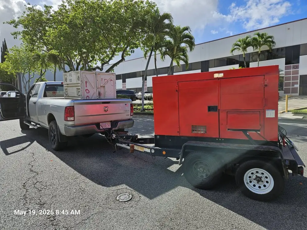 Pickup truck towing a red trailer generator
