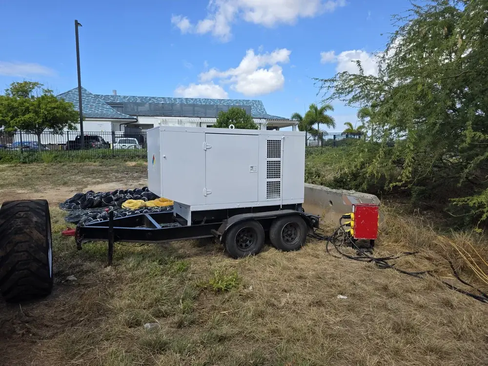 White trailer-mounted rental generator parked on a grass job site